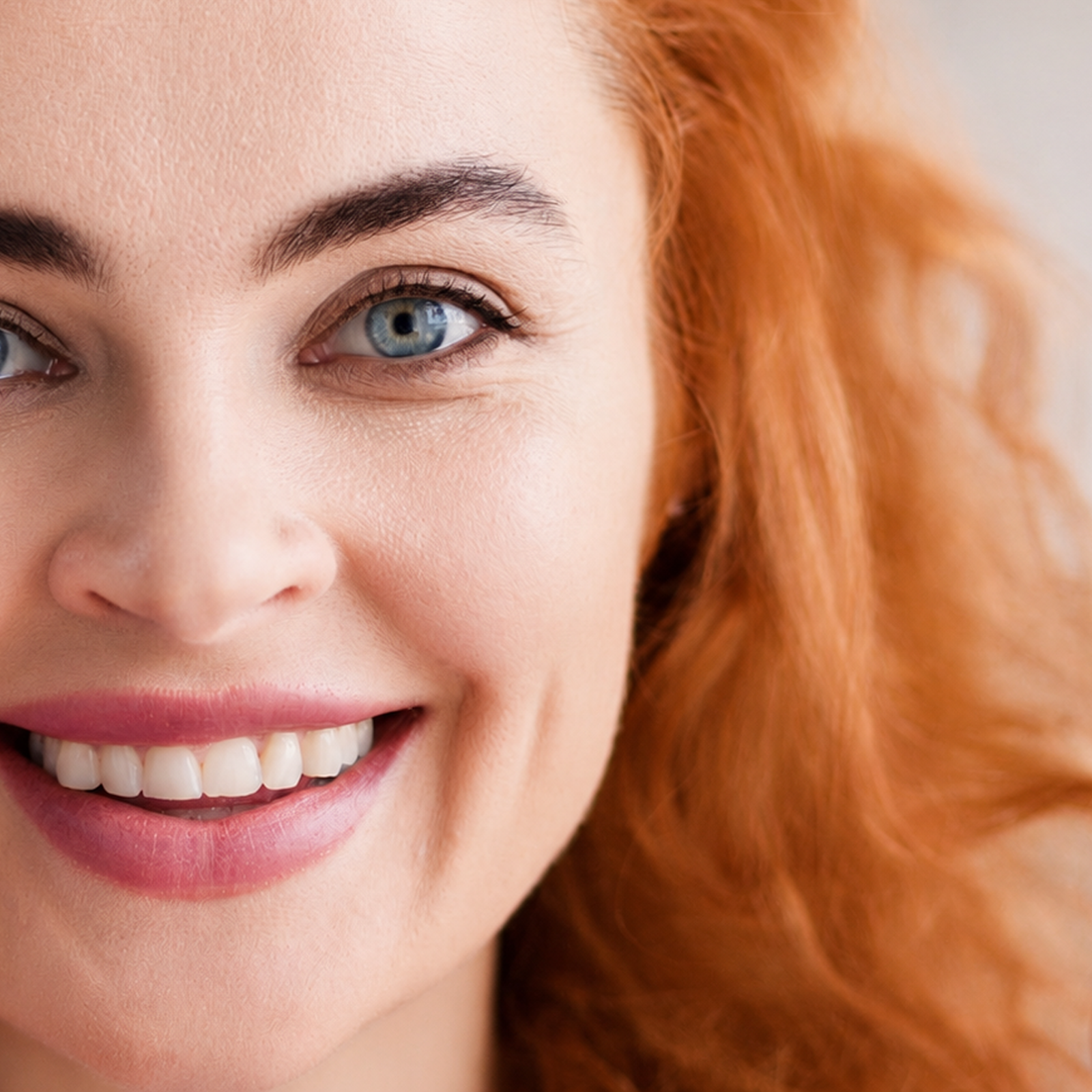Natural lashes and brows framed in soft light